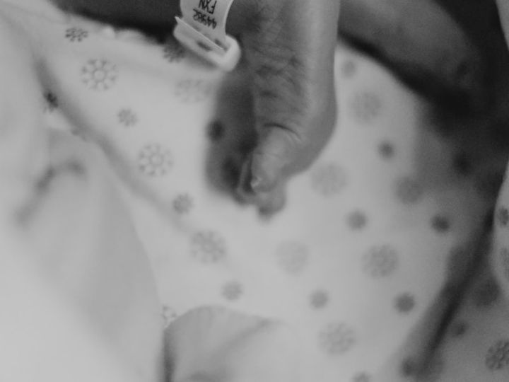 Bebé hospitalizado tomando la mano de un adulto